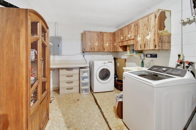 laundry room with sink, electric panel, cabinets, washing machine and clothes dryer, and a textured ceiling