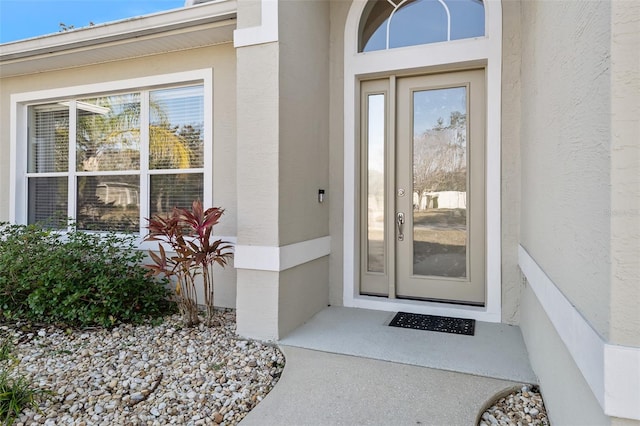 entrance to property featuring stucco siding