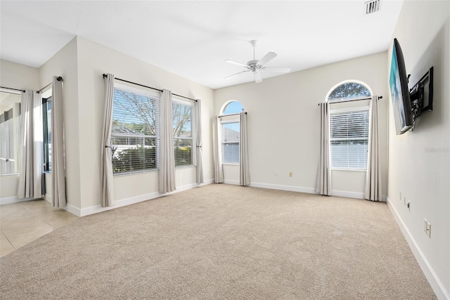 empty room featuring visible vents, light colored carpet, and plenty of natural light