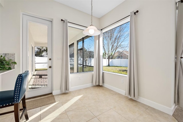 doorway featuring light tile patterned flooring and baseboards