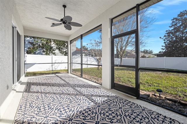 unfurnished sunroom featuring ceiling fan