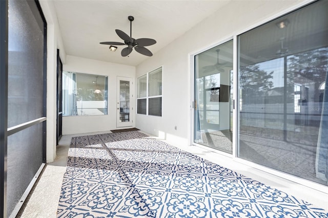 unfurnished sunroom with a healthy amount of sunlight and a ceiling fan