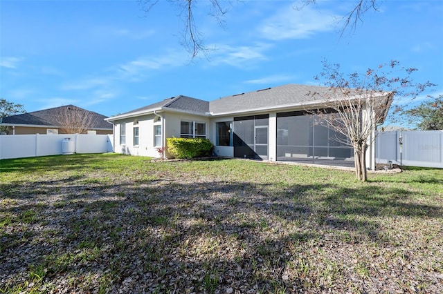 rear view of property with a lawn, a fenced backyard, and a sunroom