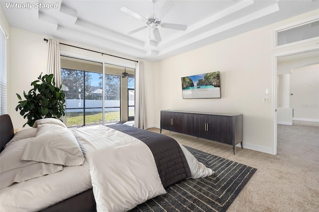 carpeted bedroom with a ceiling fan, a raised ceiling, access to exterior, and baseboards