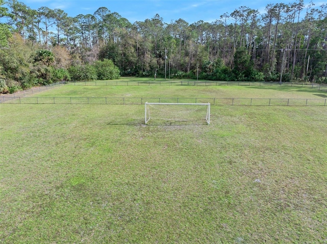 view of yard with a rural view, a forest view, and fence