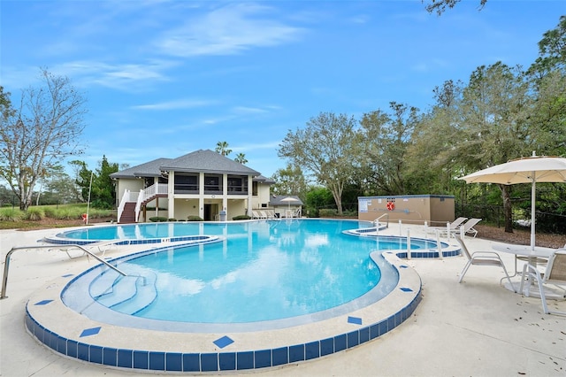 community pool featuring a patio area and stairway