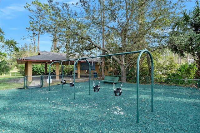 view of community featuring playground community and fence