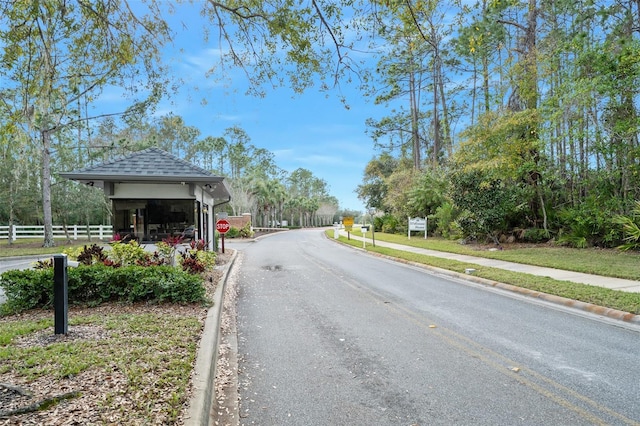 view of street featuring curbs, traffic signs, and sidewalks