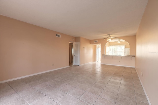 tiled empty room featuring ceiling fan