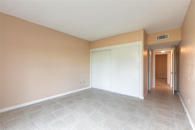 unfurnished bedroom with light tile patterned floors and a closet