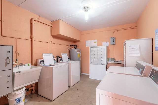 washroom with sink, electric water heater, and independent washer and dryer