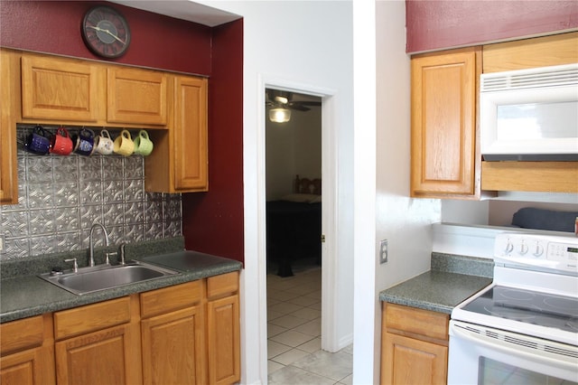 kitchen featuring sink, backsplash, white appliances, and light tile patterned floors