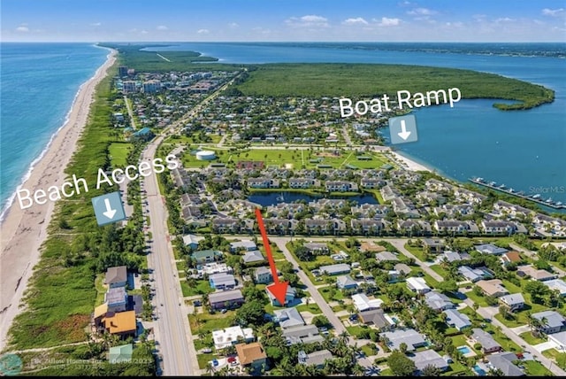 drone / aerial view featuring a water view and a view of the beach