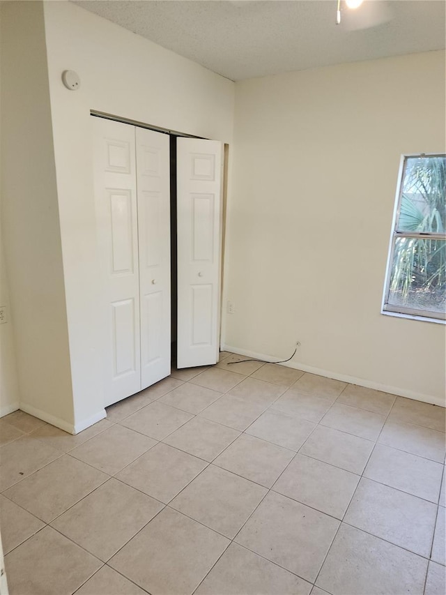 unfurnished bedroom featuring light tile patterned floors and a closet