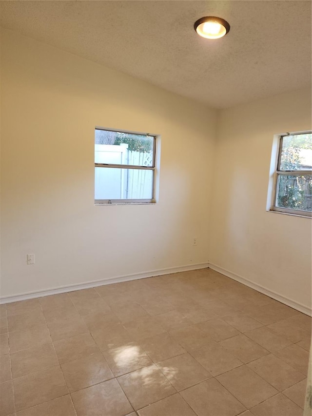 empty room with a healthy amount of sunlight and a textured ceiling