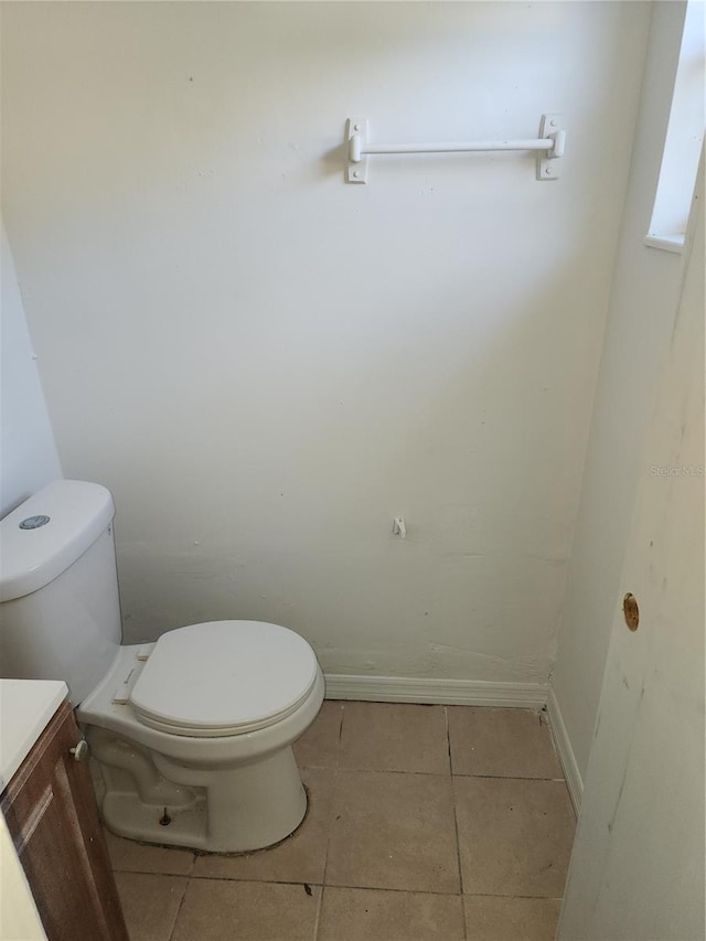 bathroom with tile patterned flooring, vanity, and toilet