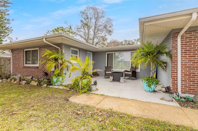 rear view of house with a patio and a lawn