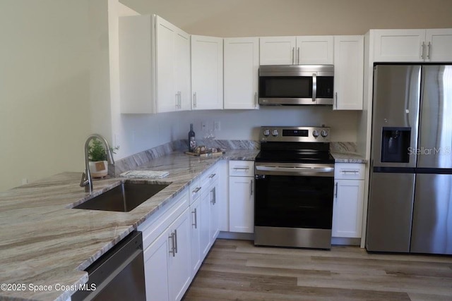 kitchen featuring light stone countertops, sink, white cabinetry, and appliances with stainless steel finishes