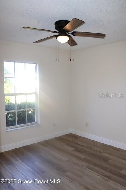 unfurnished room featuring ceiling fan, a textured ceiling, and dark hardwood / wood-style floors