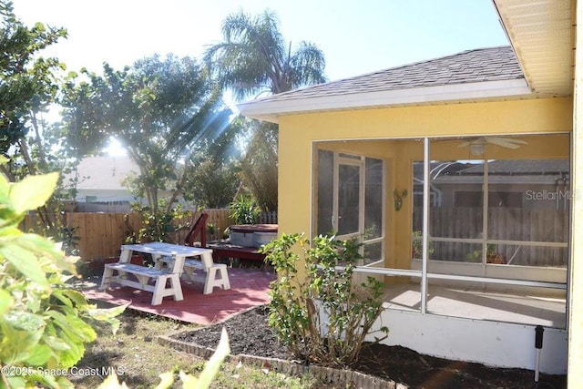 view of patio / terrace with ceiling fan, a hot tub, and a sunroom