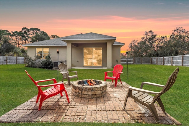 back house at dusk featuring an outdoor fire pit, a yard, and a patio