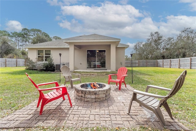 back of house with an outdoor fire pit, a patio, and a yard