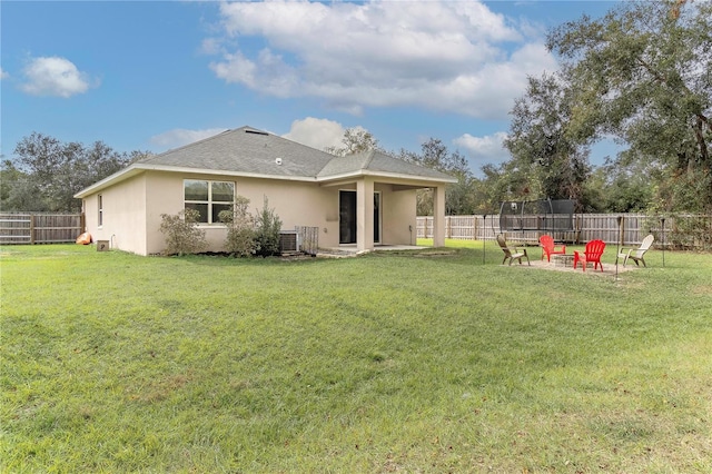 back of property with a patio area, central AC, a yard, and a fire pit