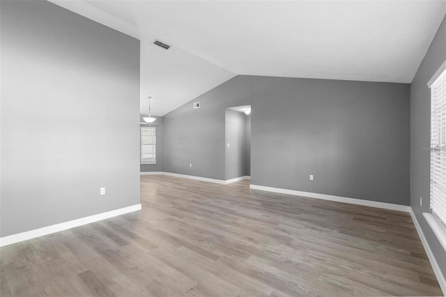 unfurnished living room with lofted ceiling and light wood-type flooring