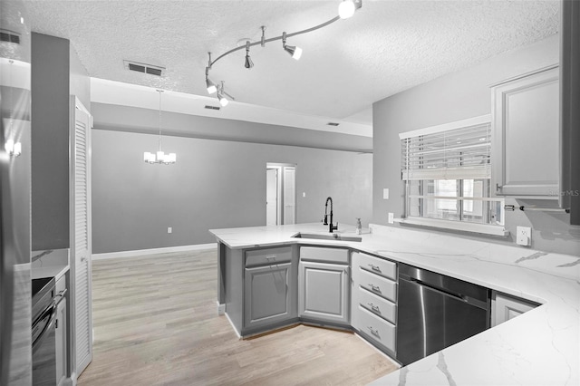 kitchen with gray cabinets, dishwasher, light stone countertops, and sink