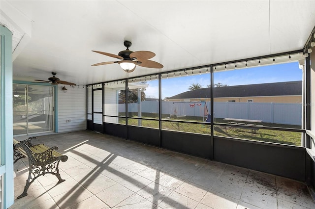 unfurnished sunroom featuring ceiling fan