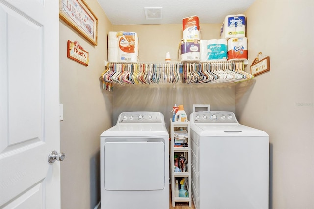 clothes washing area with separate washer and dryer