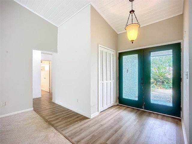 entrance foyer with lofted ceiling, light hardwood / wood-style floors, and french doors