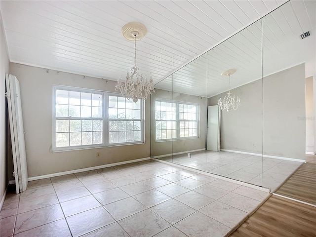 unfurnished dining area with a notable chandelier, wood ceiling, and light tile patterned flooring