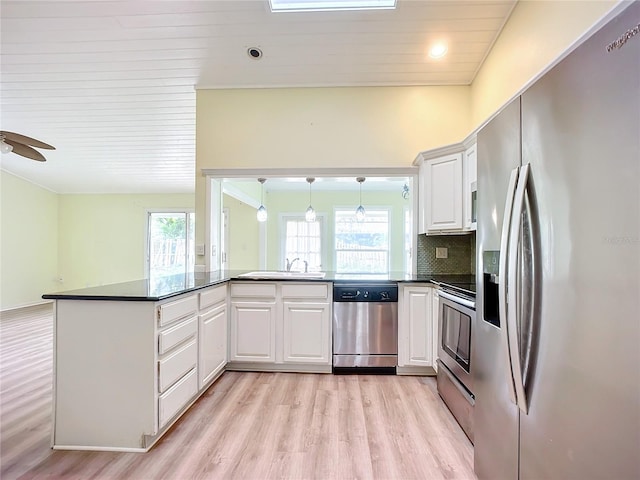 kitchen featuring white cabinetry, kitchen peninsula, and appliances with stainless steel finishes