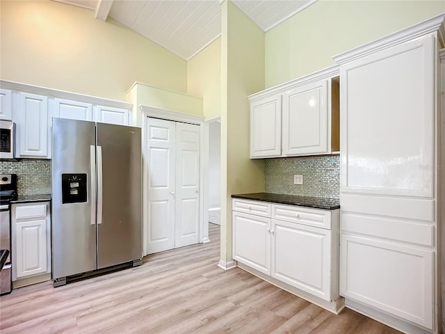 kitchen featuring white cabinetry, stainless steel appliances, decorative backsplash, and beamed ceiling