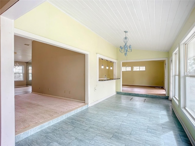 unfurnished room with lofted ceiling, wood ceiling, and a chandelier