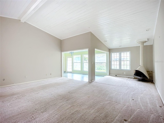 unfurnished living room with light carpet, vaulted ceiling with beams, wooden ceiling, and a wood stove