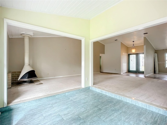 unfurnished living room featuring french doors, wooden ceiling, vaulted ceiling, and a wood stove