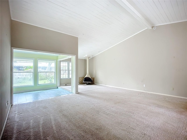 unfurnished living room featuring vaulted ceiling with beams, light colored carpet, wooden ceiling, and a wood stove