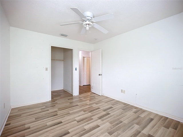 unfurnished bedroom with ceiling fan, a closet, and light wood-type flooring