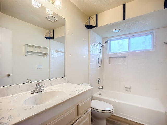 full bathroom featuring hardwood / wood-style floors, vanity, a textured ceiling, toilet, and tiled shower / bath