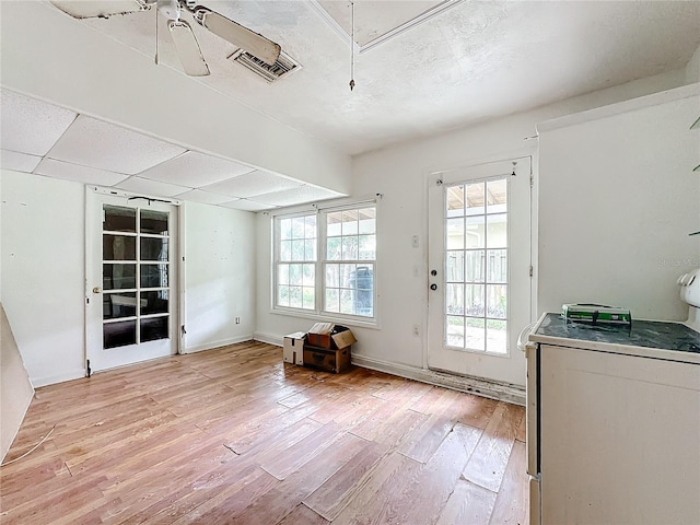 doorway with ceiling fan and light wood-type flooring