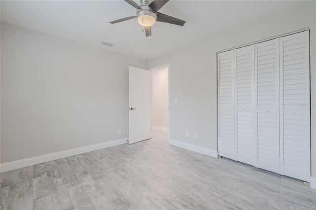 unfurnished bedroom with light hardwood / wood-style flooring, a closet, and ceiling fan