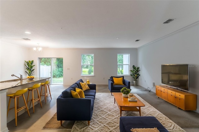 living room with crown molding, an inviting chandelier, and sink