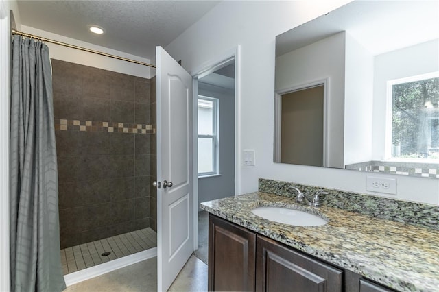 bathroom featuring vanity, curtained shower, and a textured ceiling