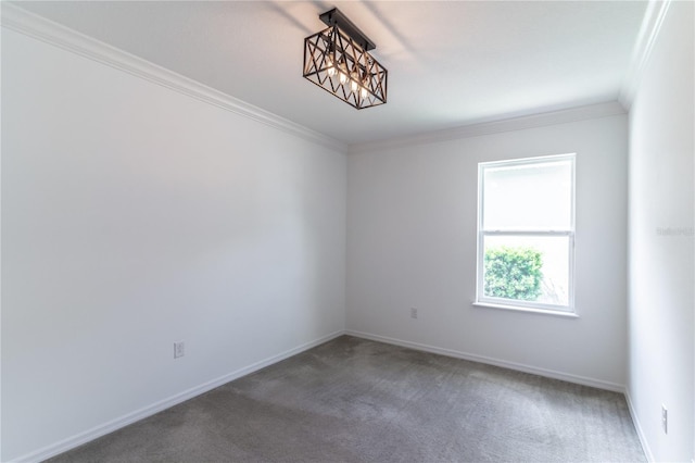 carpeted spare room featuring an inviting chandelier and ornamental molding