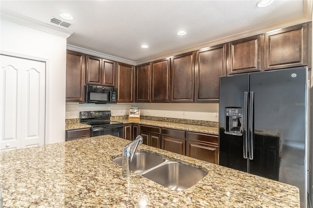 kitchen with light stone countertops, dark brown cabinets, ornamental molding, and black appliances