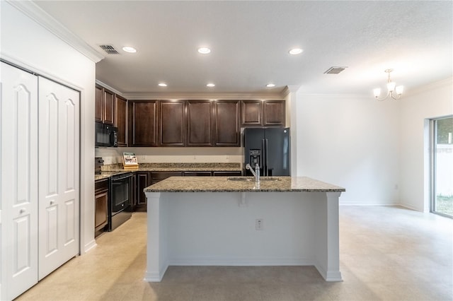 kitchen featuring dark brown cabinetry, sink, a center island with sink, and black appliances