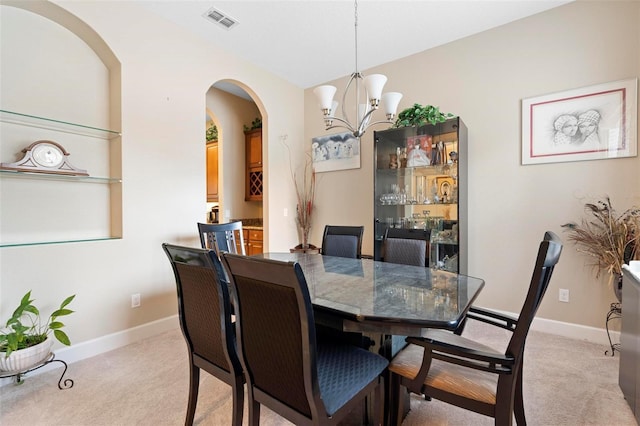 dining room with an inviting chandelier and light colored carpet