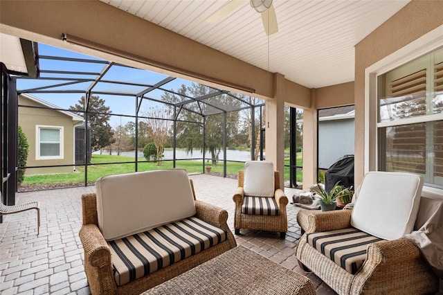 view of patio / terrace featuring a lanai, outdoor lounge area, and a water view